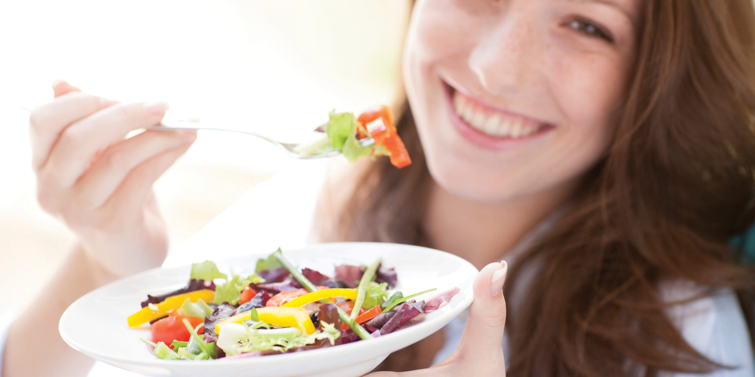 Young woman eating a salad