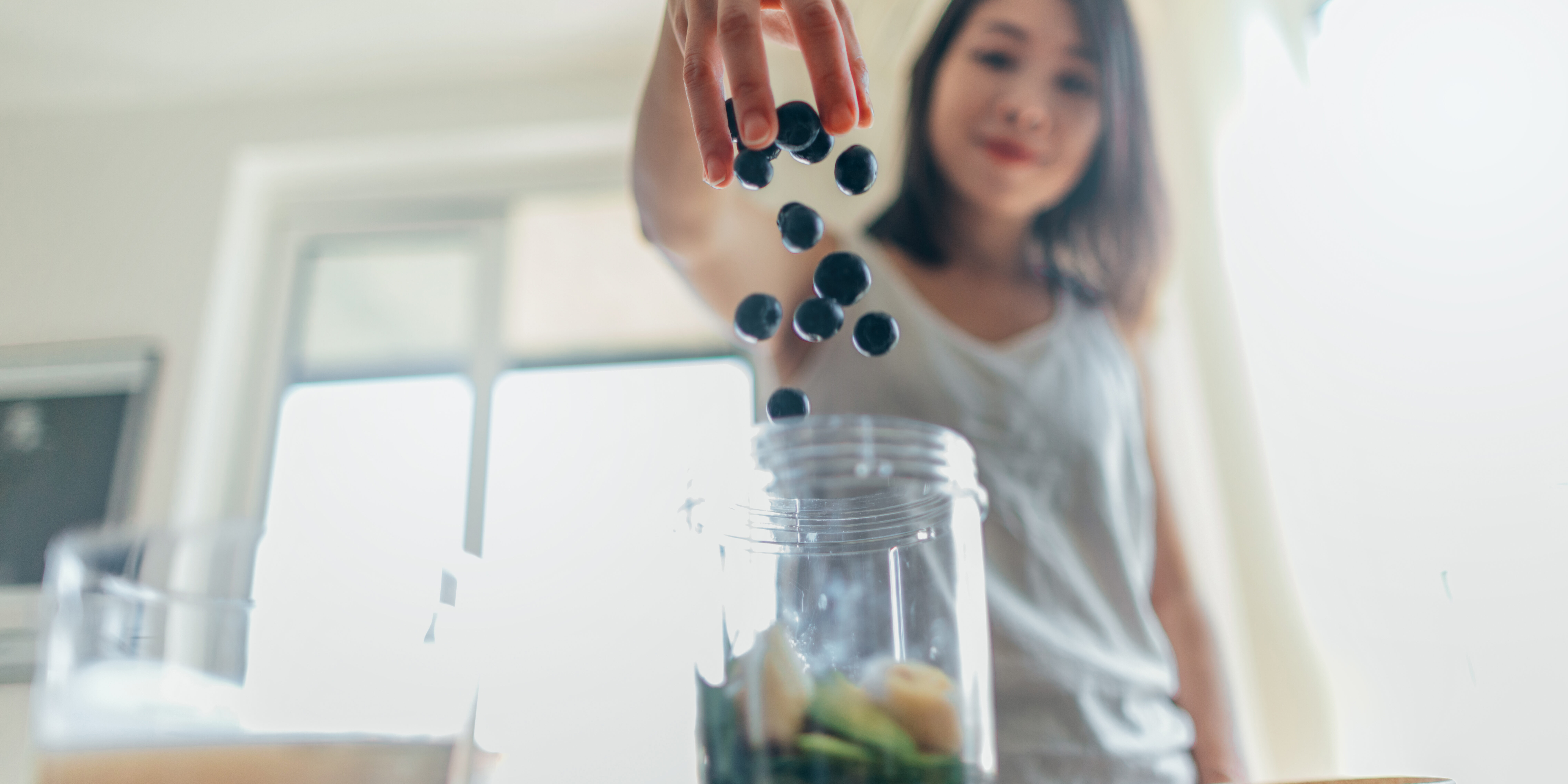 Young Woman Making Healthy Smoothie For Breakfast