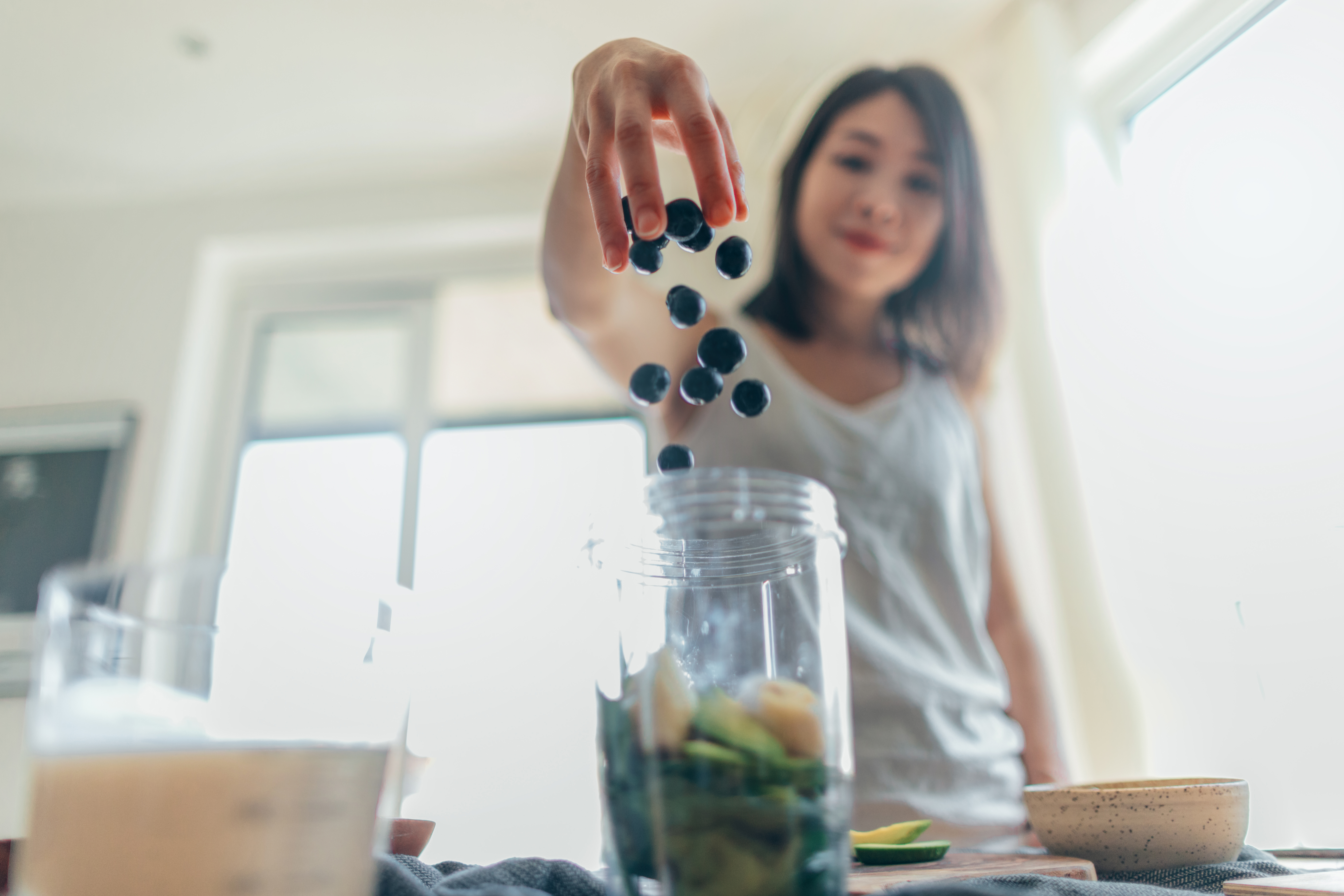 Young Woman Making Healthy Smoothie For Breakfast