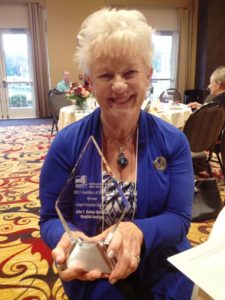 Mather Auxiliary President Barbara Zinna holds the Auxiliary of the Year award.