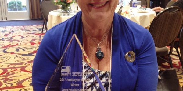 Mather Auxiliary President Barbara Zinna holds the Auxiliary of the Year award.