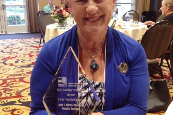 Mather Auxiliary President Barbara Zinna holds the Auxiliary of the Year award.