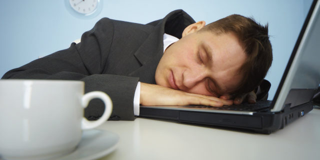 Tired man sleeping on a notebook