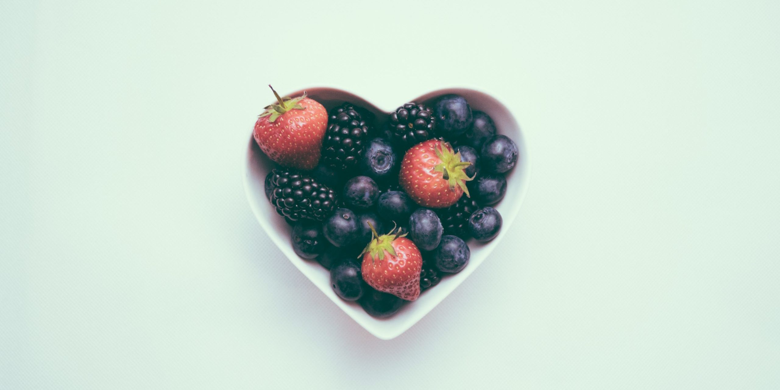 Berries in heart shaped dish Foods to eat for a healthier heart