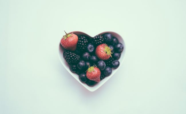 Berries in heart shaped dish Foods to eat for a healthier heart
