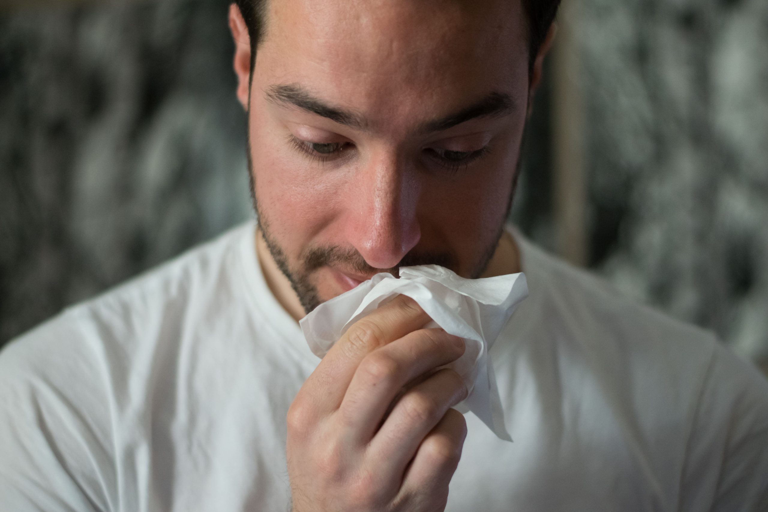 Man wiping nose with tissue