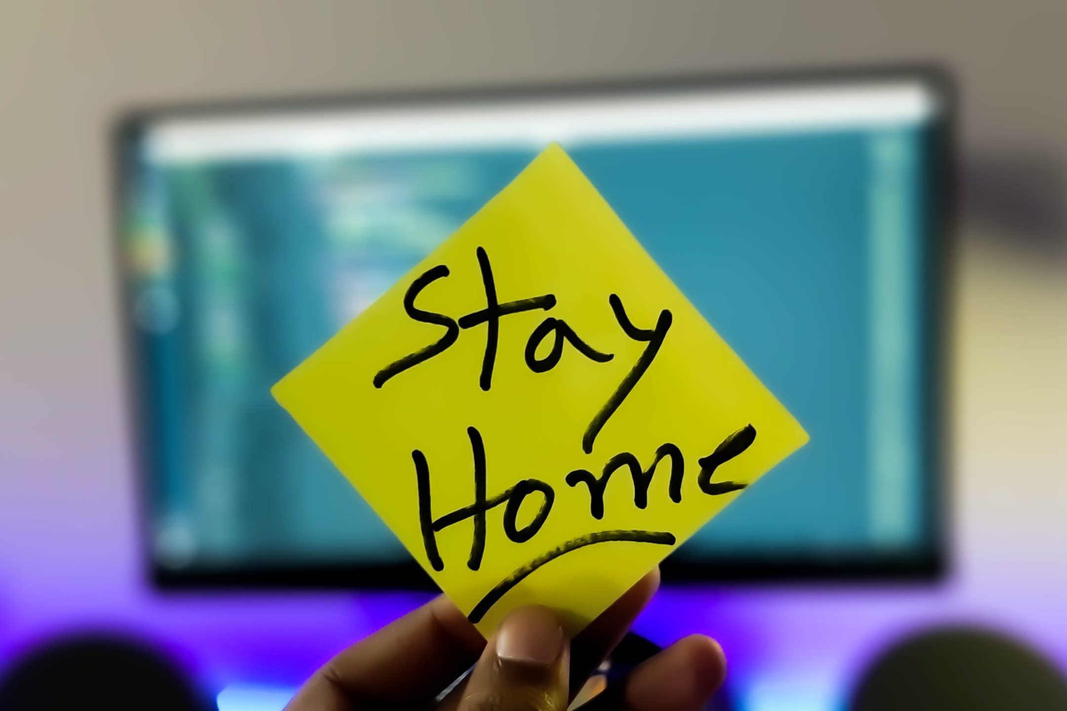Stay home written on a yellow post-it Stay home written on a yellow post-it