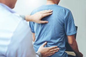 Chiropractor evaluating patient's back pain