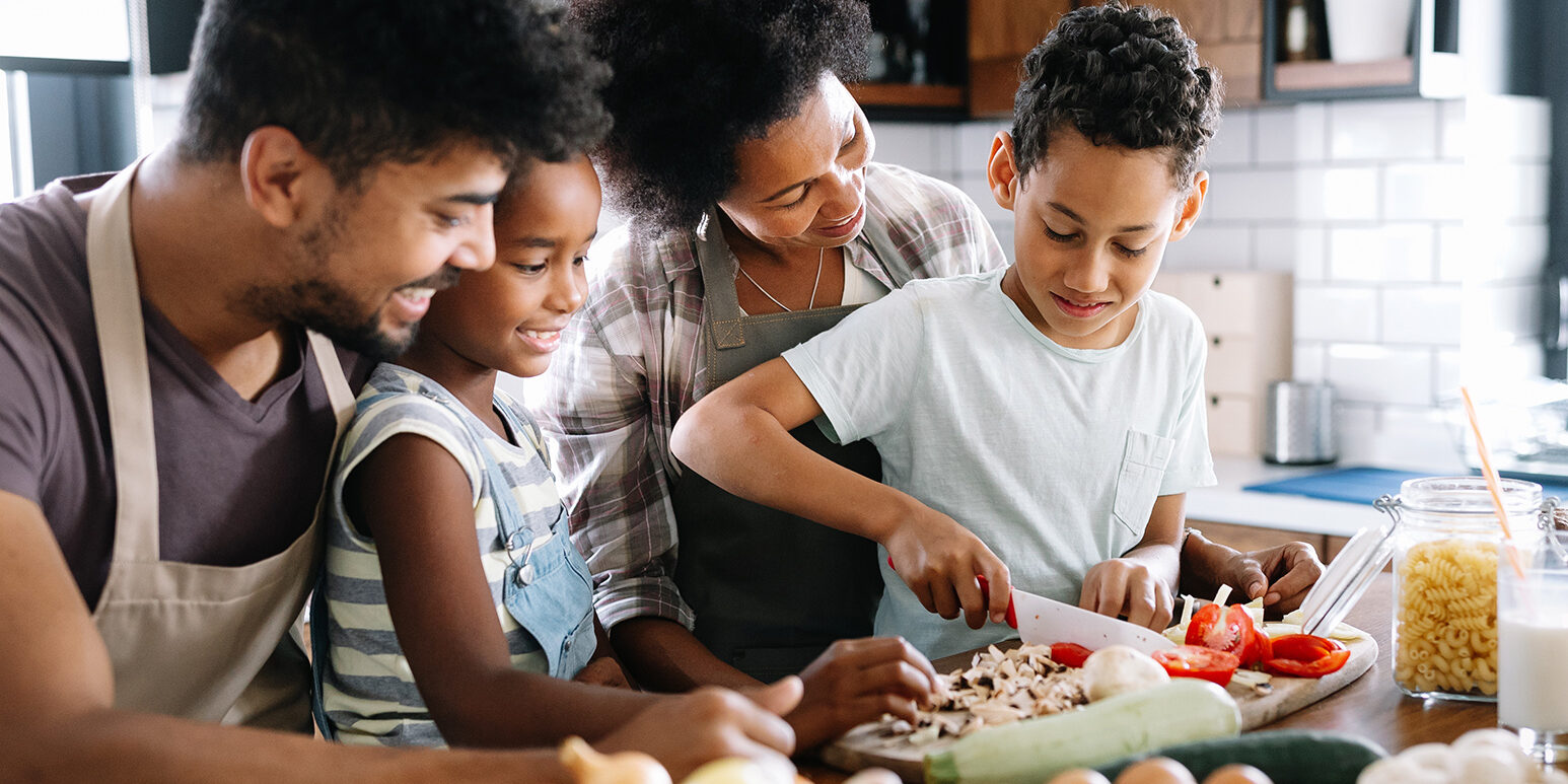 Happy family in the kitchen having fun and cooking together. Healthy food at home.