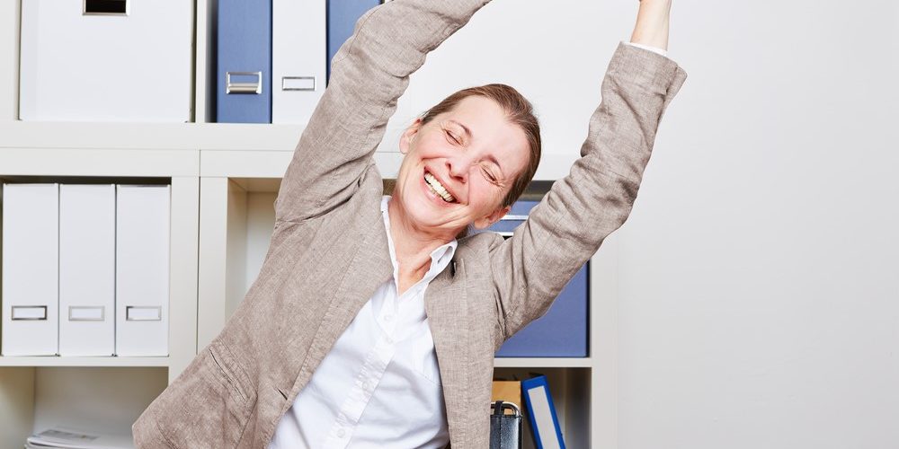 Back Pain Stretching – Take back the New Year blog 2021 Woman stretching at work desk