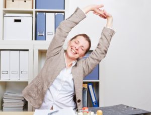 Woman stretching at work desk