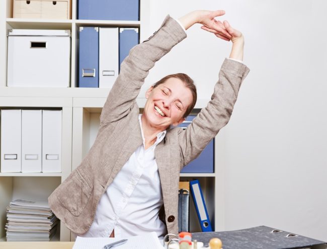 Back Pain Stretching – Take back the New Year blog 2021 Woman stretching at work desk
