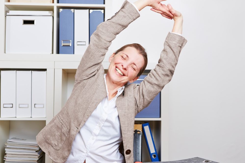 Woman stretching at work desk