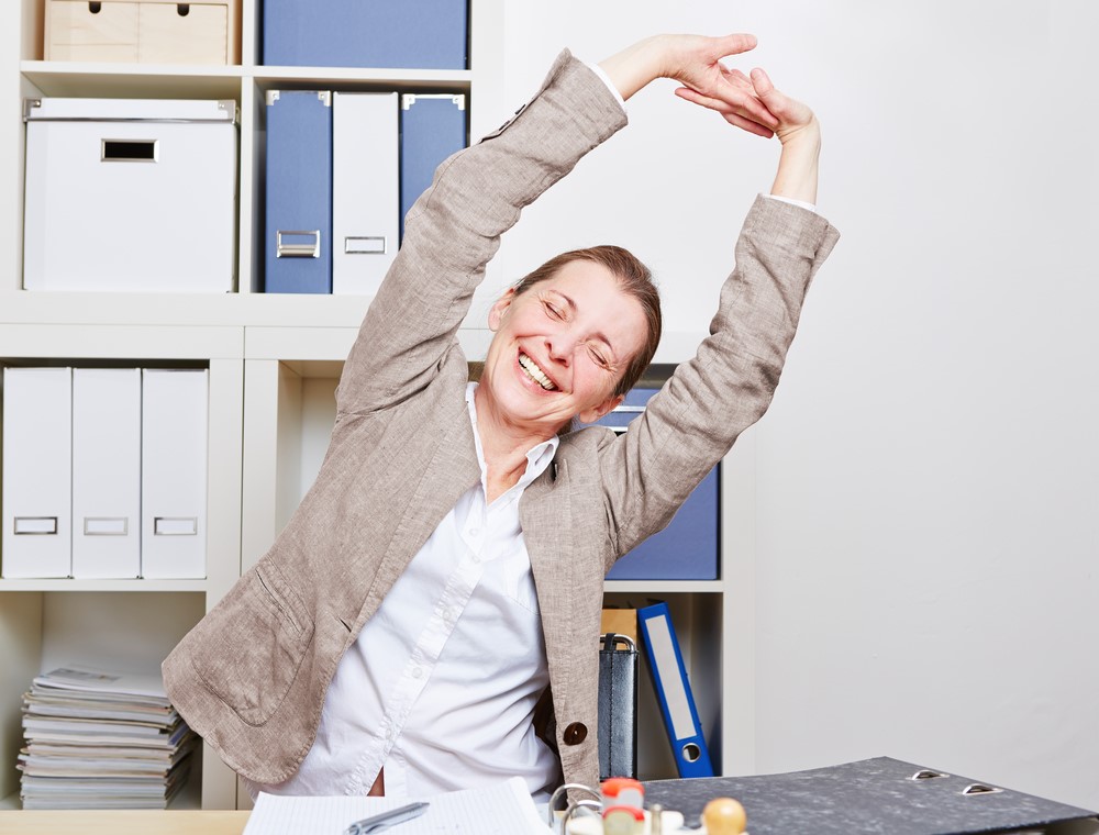 Back Pain Stretching – Take back the New Year blog 2021 Woman stretching at work desk