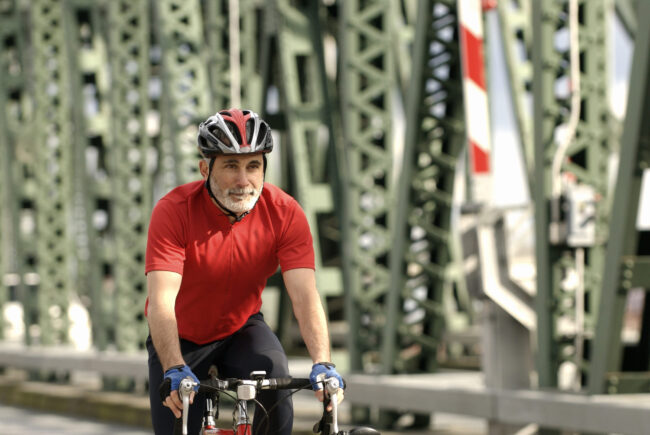 Man riding bicycle over bridge