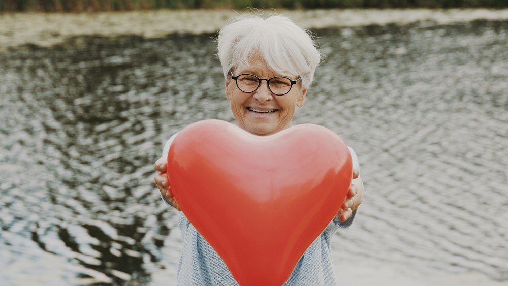 Heart disease and dementia Woman holding heart-shaped balloon