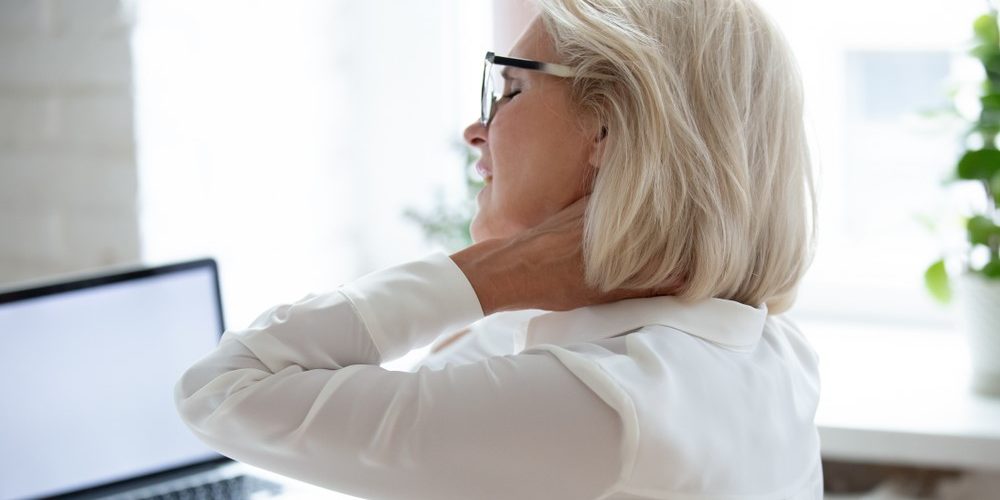 Neck pain Woman sitting in front of computer with neck pain
