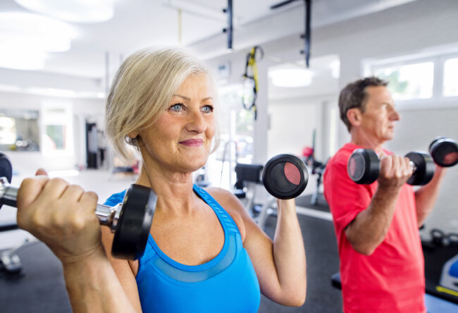Mature woman and senior man working out in fitness gym