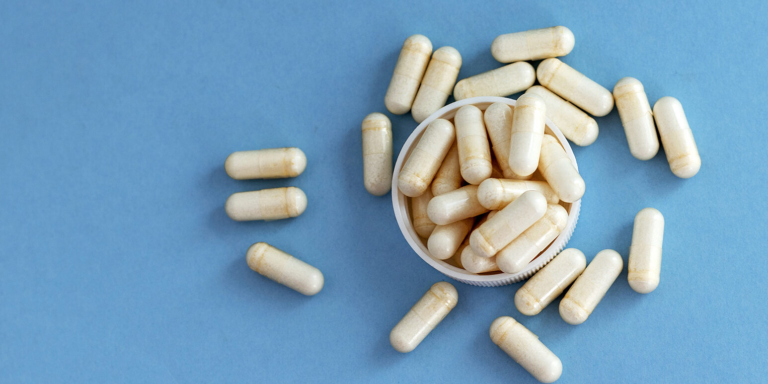 white pills bottle with vitamin c capsules with stethoscope and