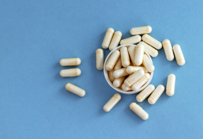 white pills bottle with vitamin c capsules with stethoscope and