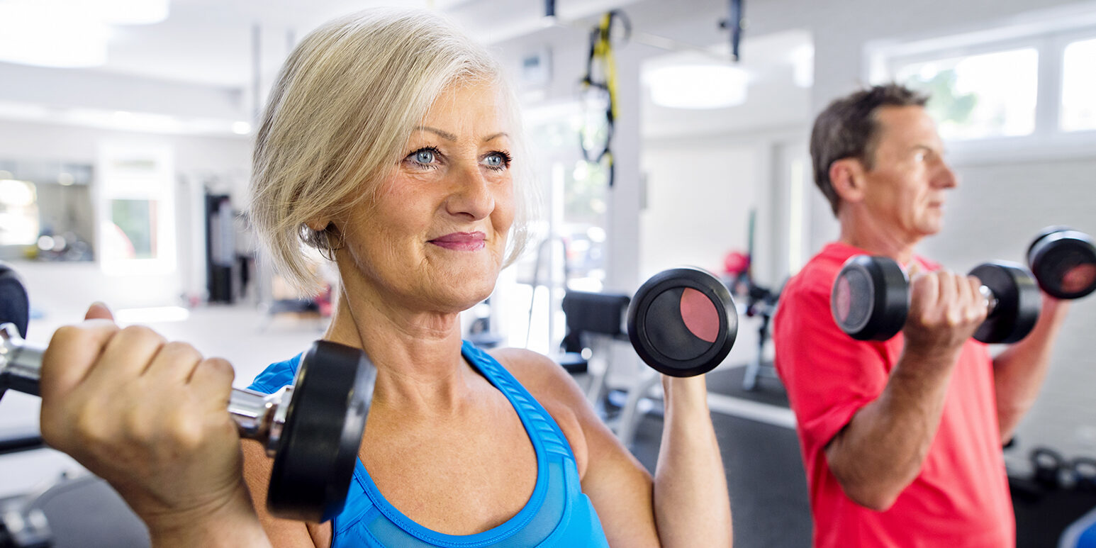 Mature woman and senior man working out in fitness gym