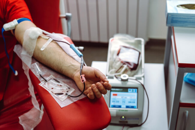 The hand of a man who donates blood. Male donor gives blood in a blood donation center