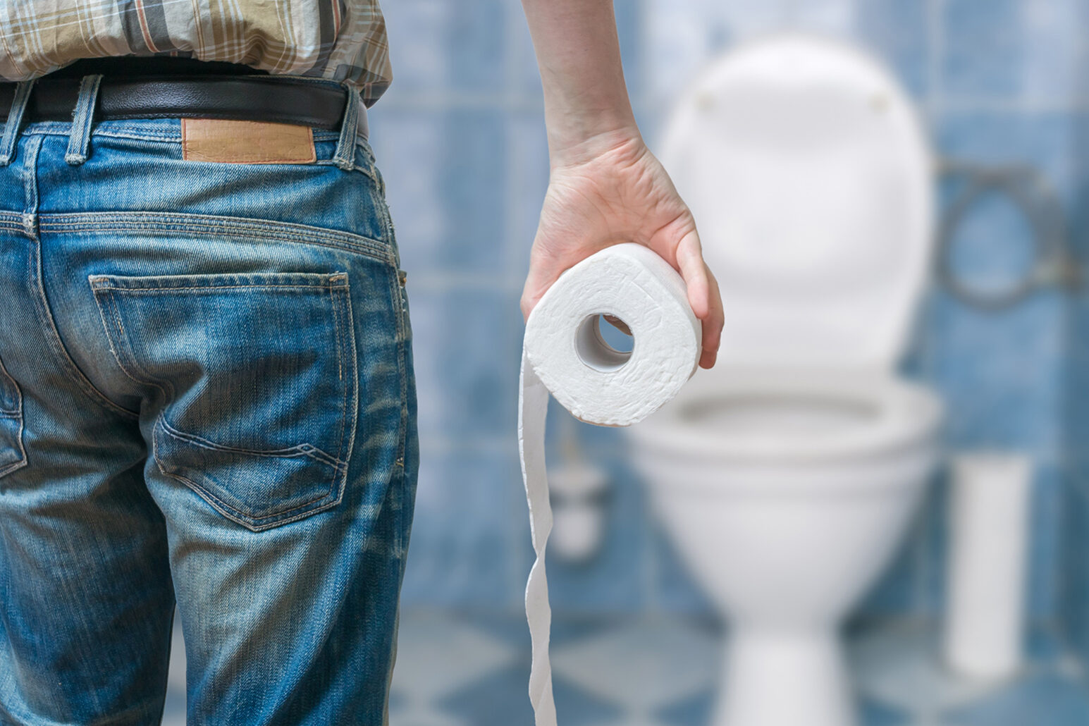 Man suffers from diarrhea holds toilet paper roll in front of to