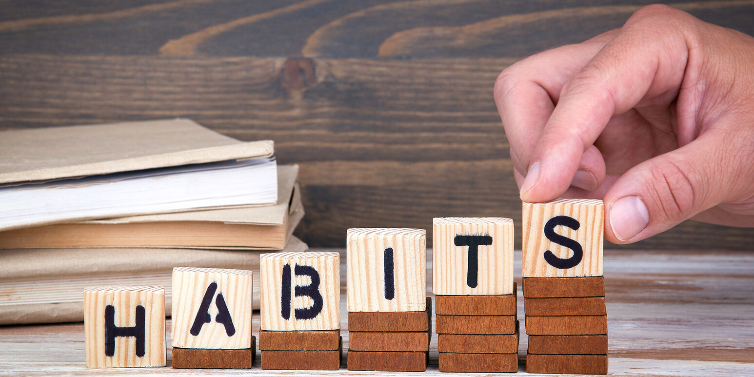 Habits concept. Wooden letters on the office desk, informative a