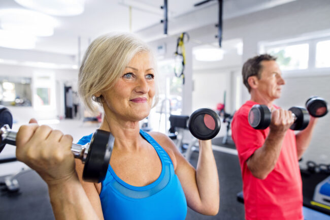 Mature woman and senior man working out in fitness gym