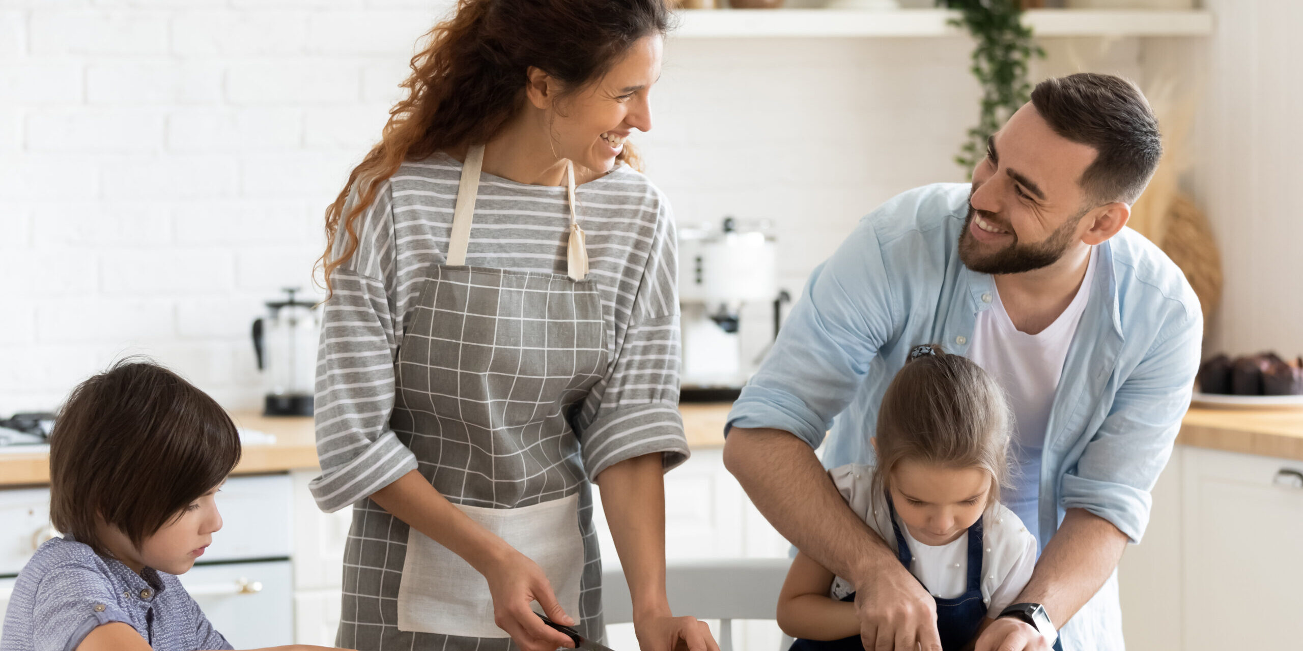 Full family with kids chatting and preparing healthy vegetarian salad