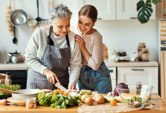 Happy mother and daughter preparing healthy food at home
