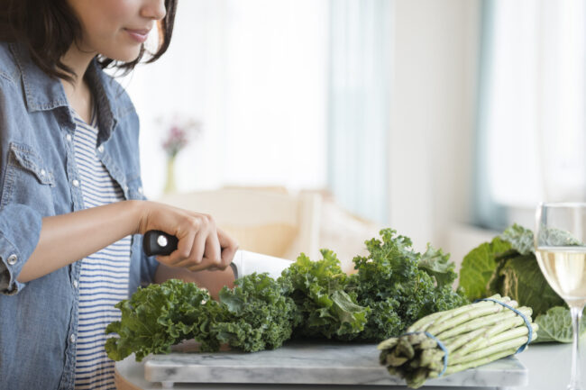 Hispanic woman chopping salad greens